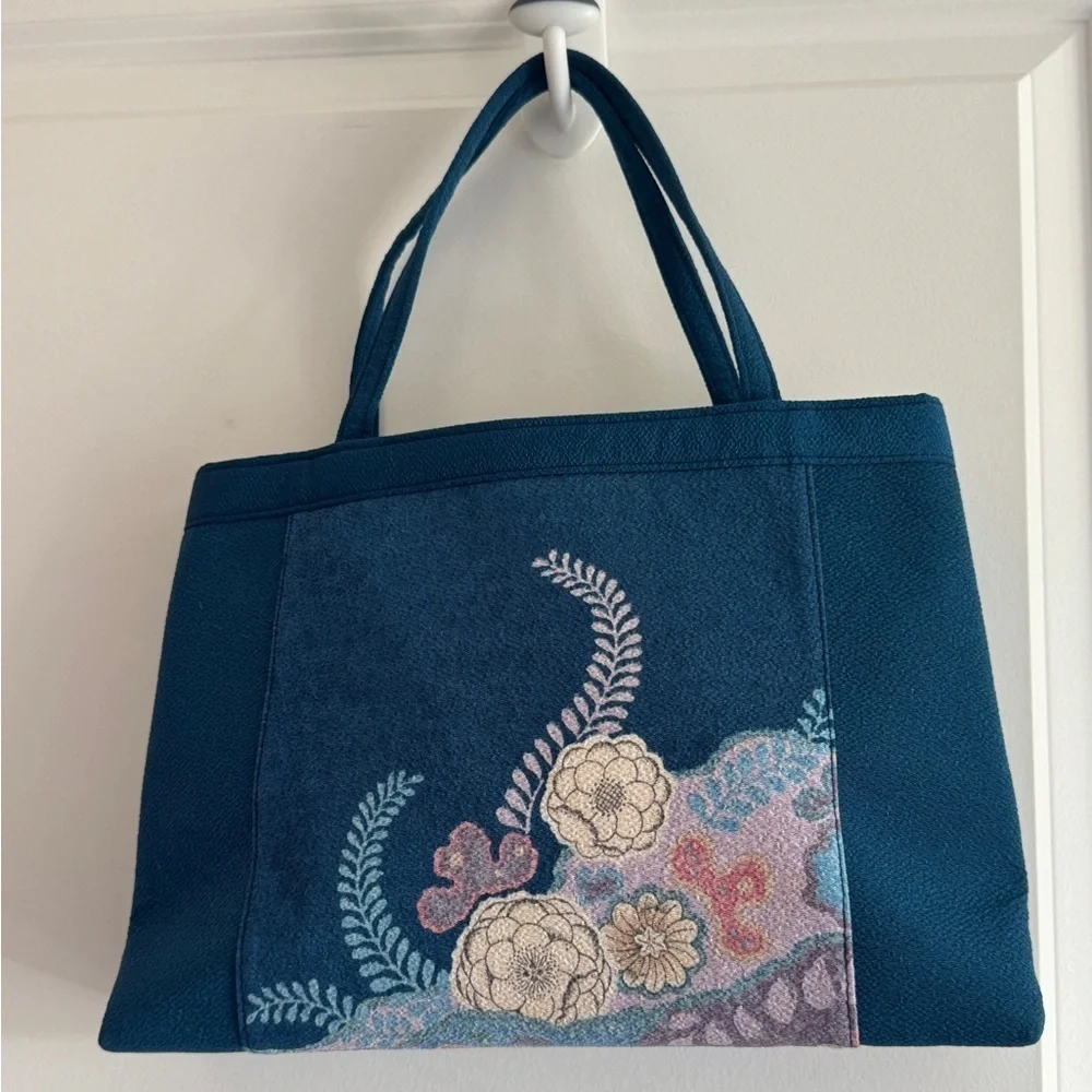 Teal-colored‎ handbag bag featuring intricate floral embroidery